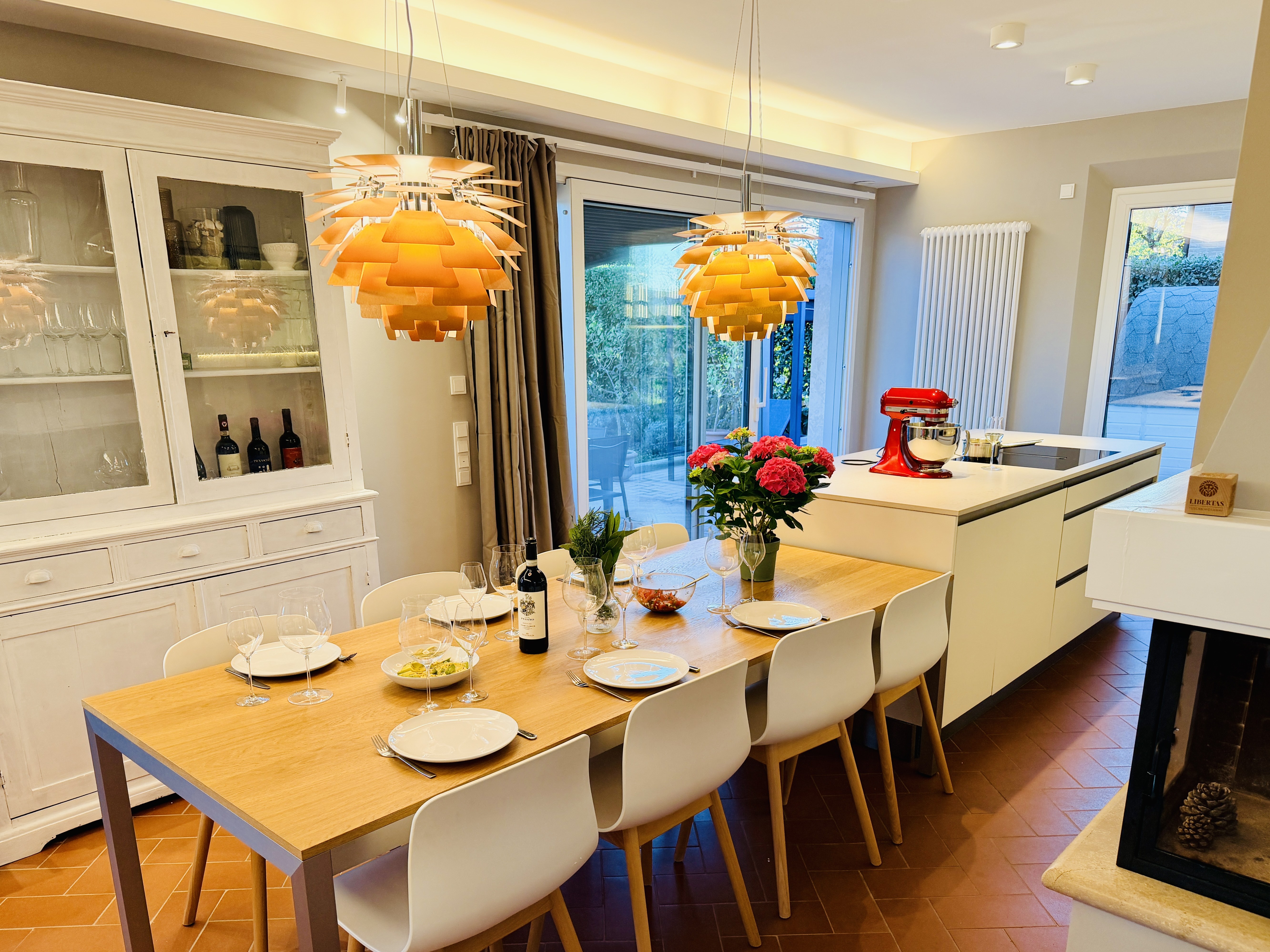 Designer kitchen and dining area, set table with PH Artichoke lamps