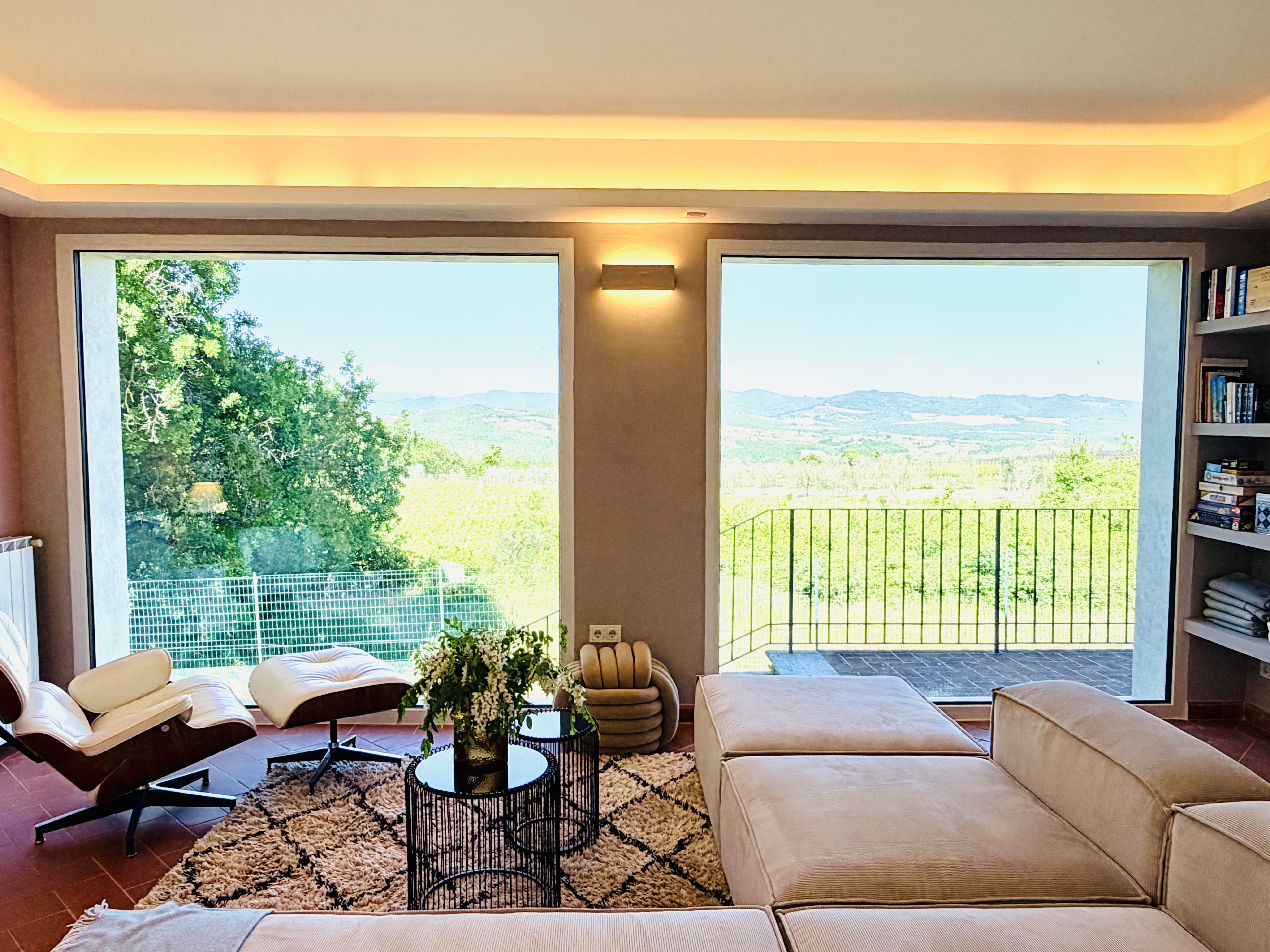 Panoramic living room windows overlooking Chianti Classico vineyards in summer
