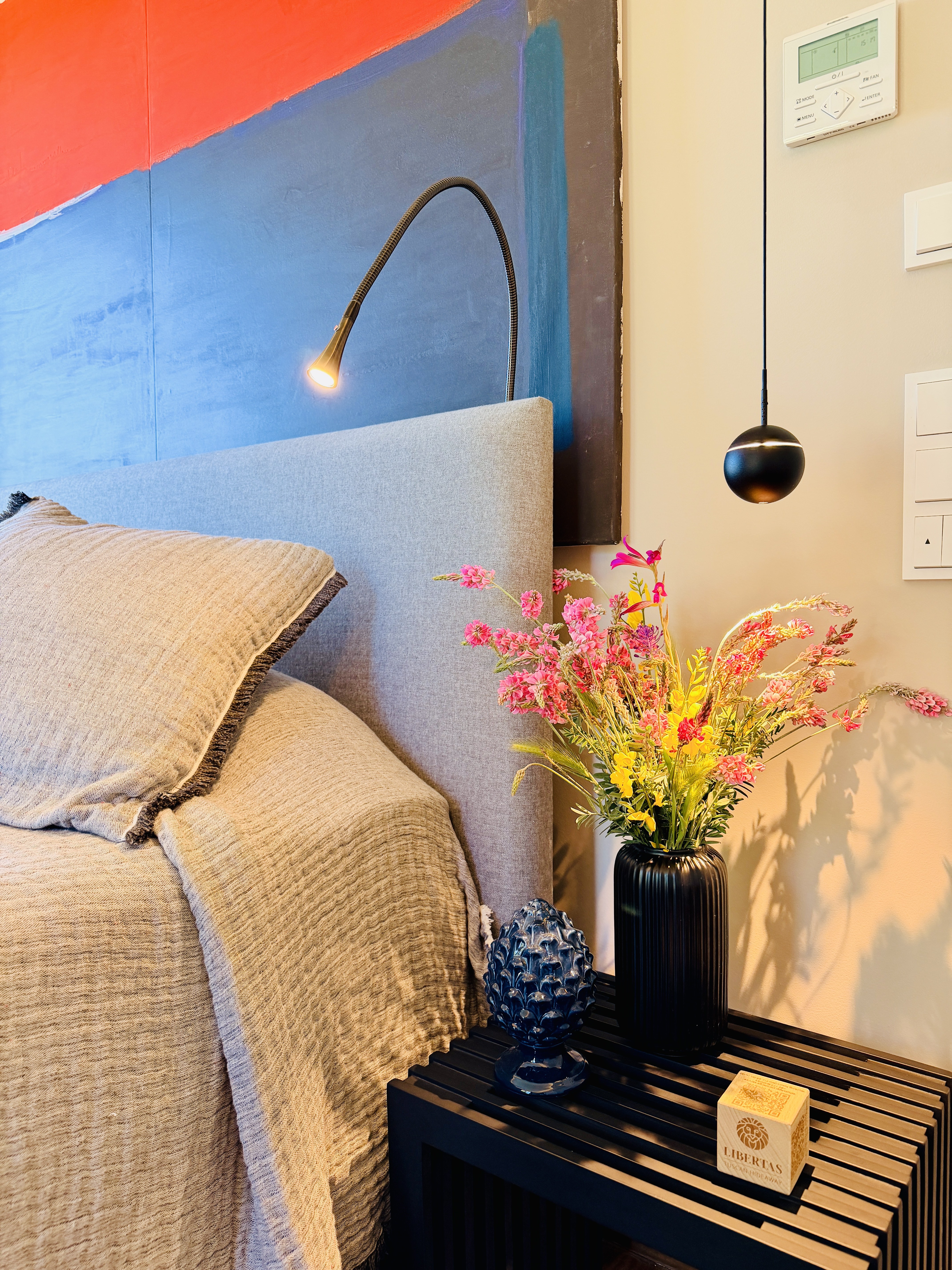 Master Bedroom 1 bedside detail with reading lamp and wildflowers